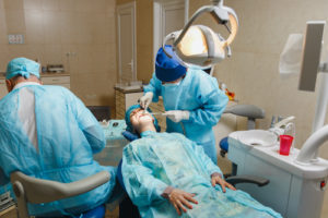 dentists performing oral surgery on a patient