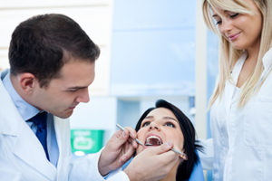 dentist determining if patient needs dental fillings or dental sealants 